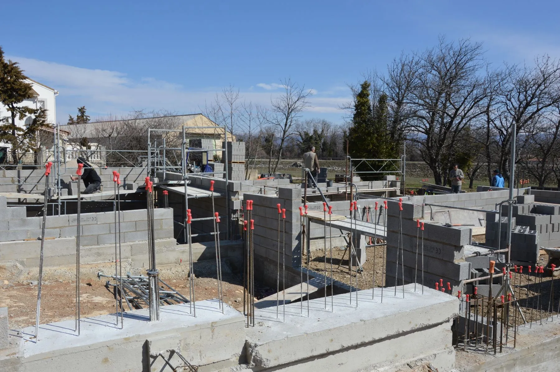 Obra en construcción con paredes de bloques y columnas de hierro