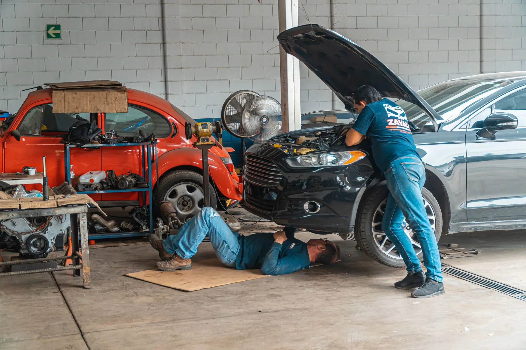 Mecánicos trabajando en autos dentro de un taller