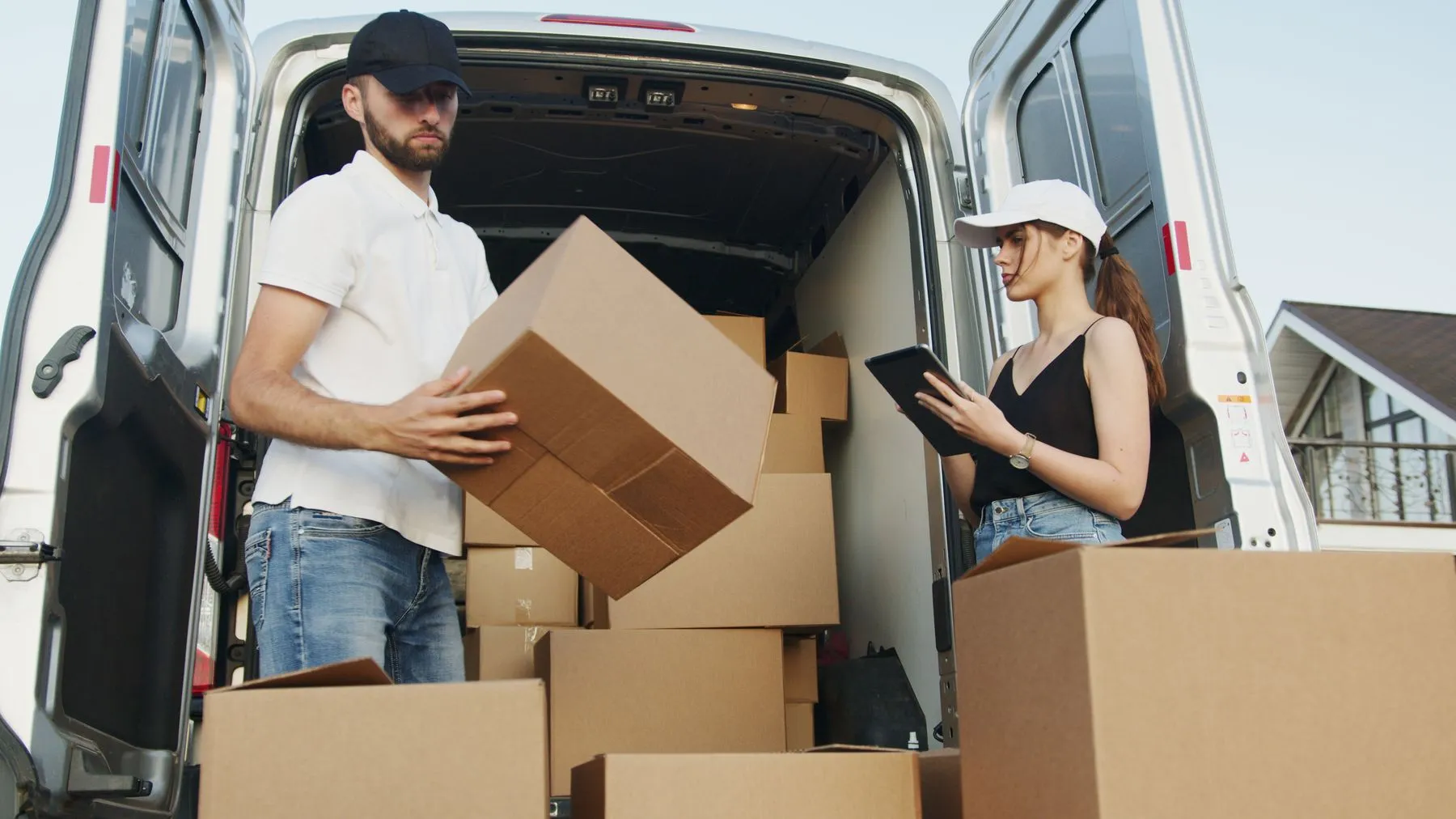 Ayudantes cargando cajas en un utilitario de flete