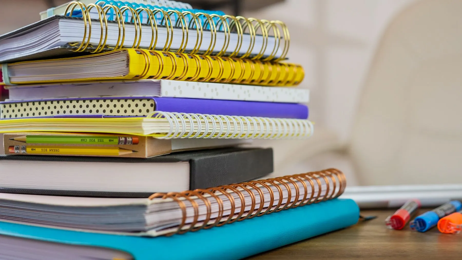 Pila de cuadernos espirales de colores sobre un escritorio