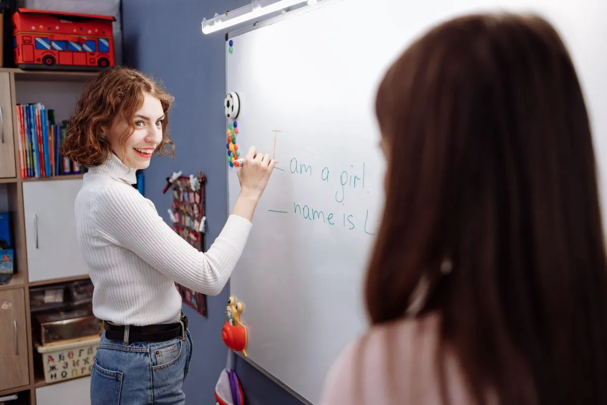 Alumna escribiendo una frase en inglés en la pizarra