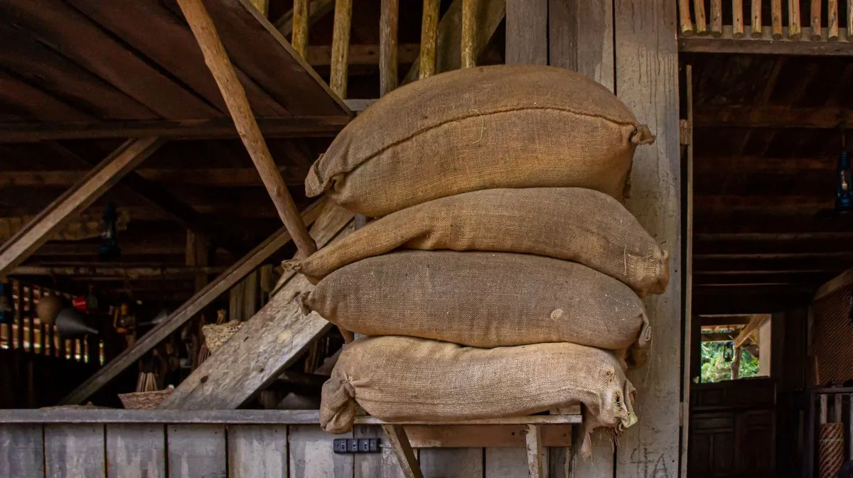Bolsas de arpillera apiladas en un galpón de madera