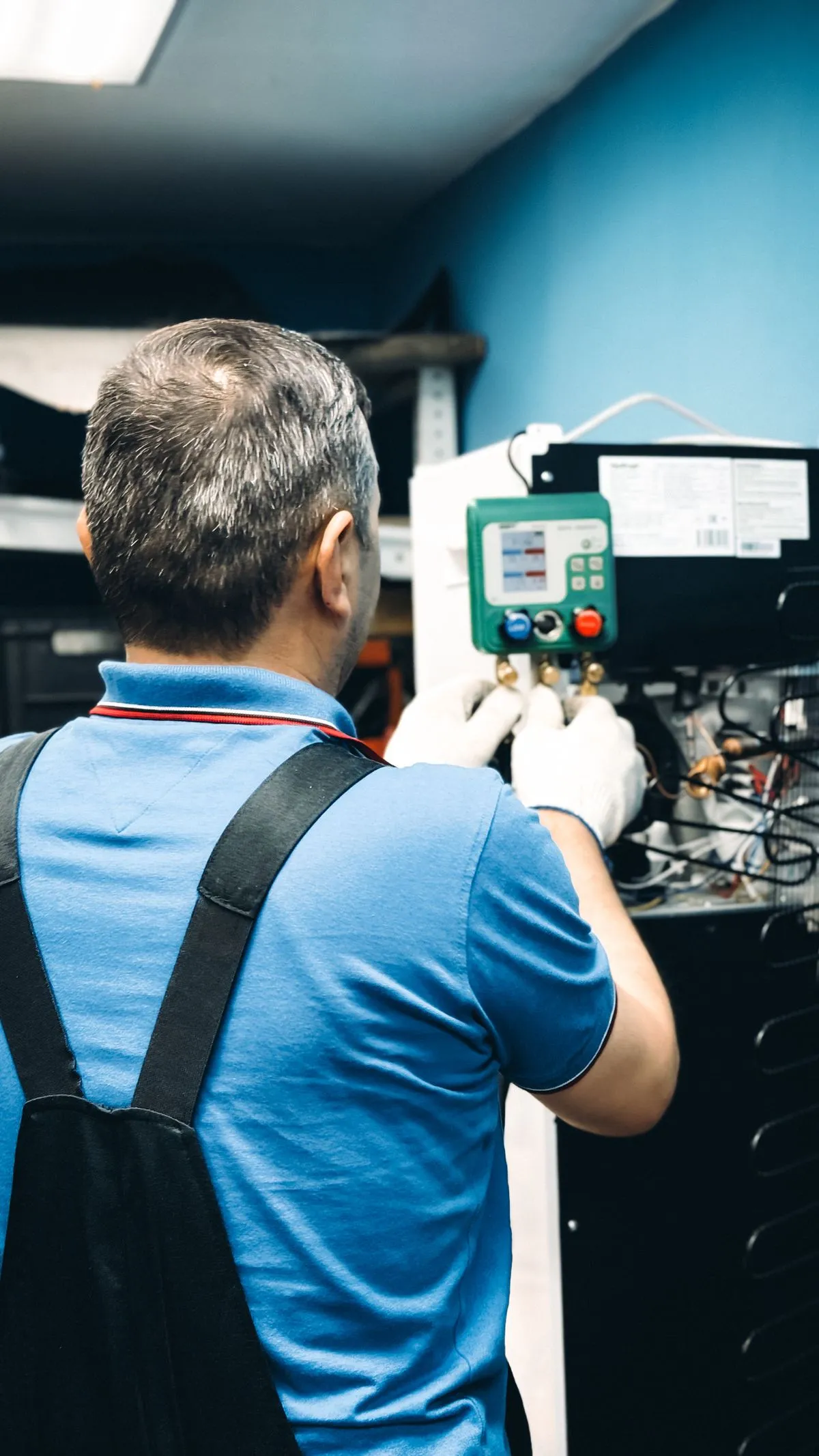 Técnico revisando un equipo de aire acondicionado con manómetro