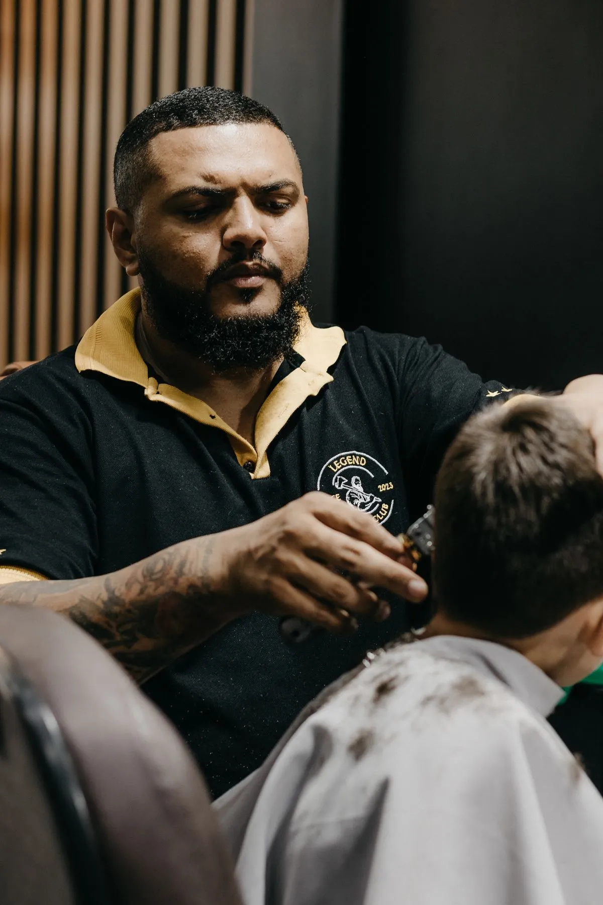 Barbero cortándole el pelo a un niño, visto de espaldas