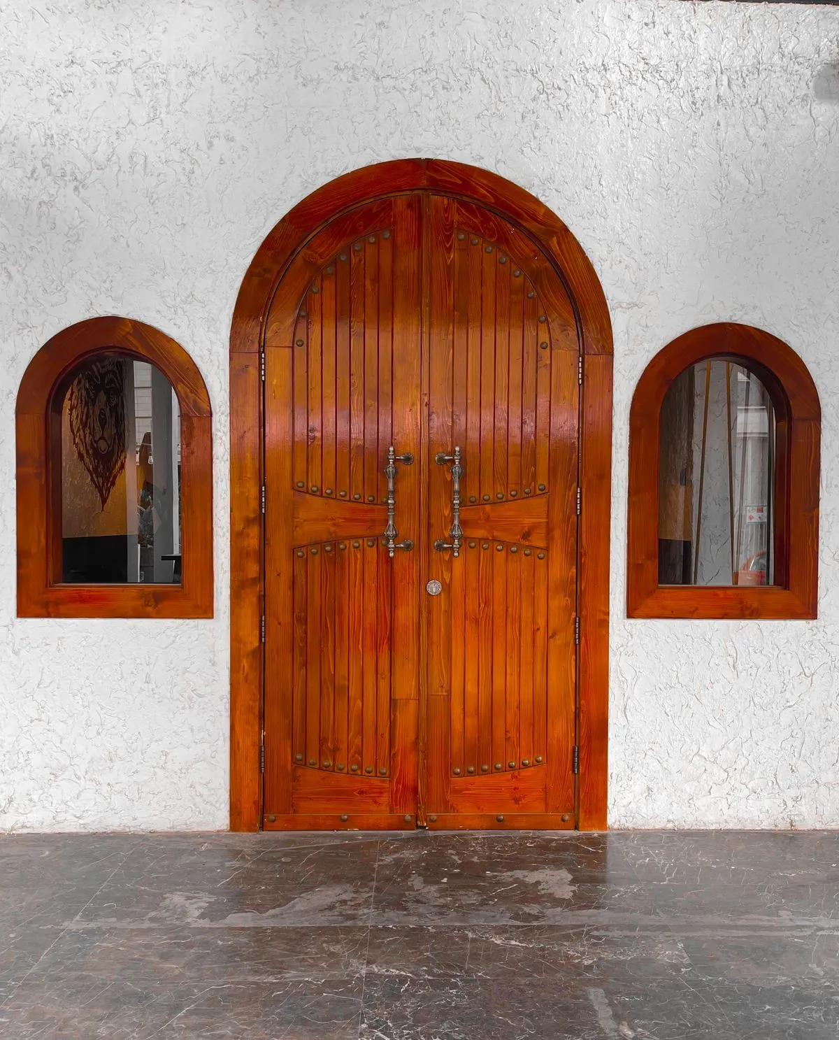 Puerta de entrada de madera maciza barnizada, con arco