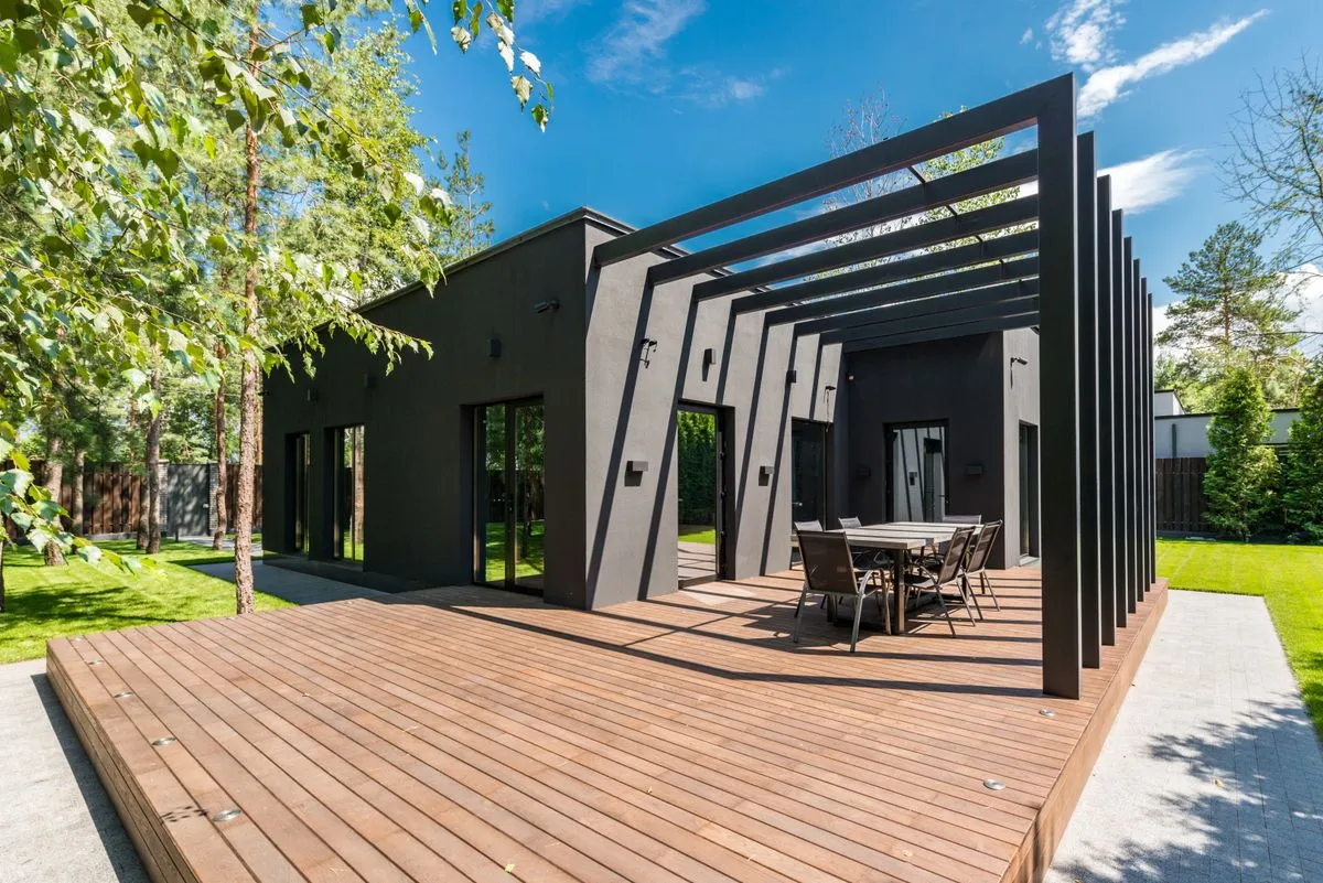 Deck de madera en el patio de una casa, con pérgola