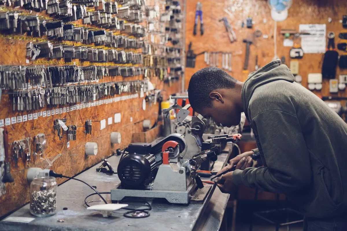 Cerrajero haciendo una copia de llave en la máquina del taller