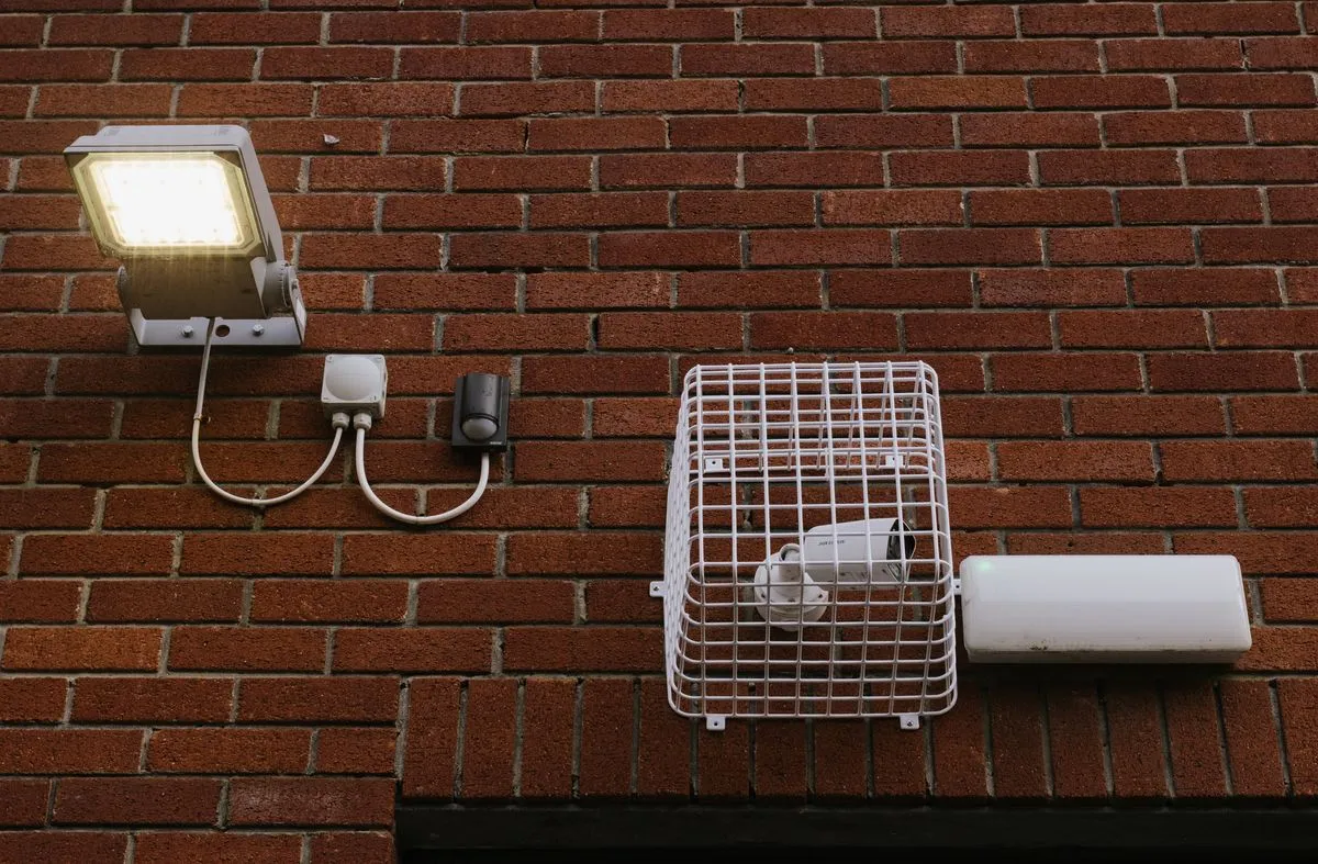 Reflector LED con sensor instalado en una pared de ladrillo