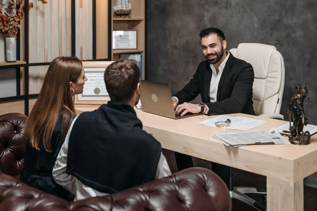Abogado asesorando a dos clientes en el estudio