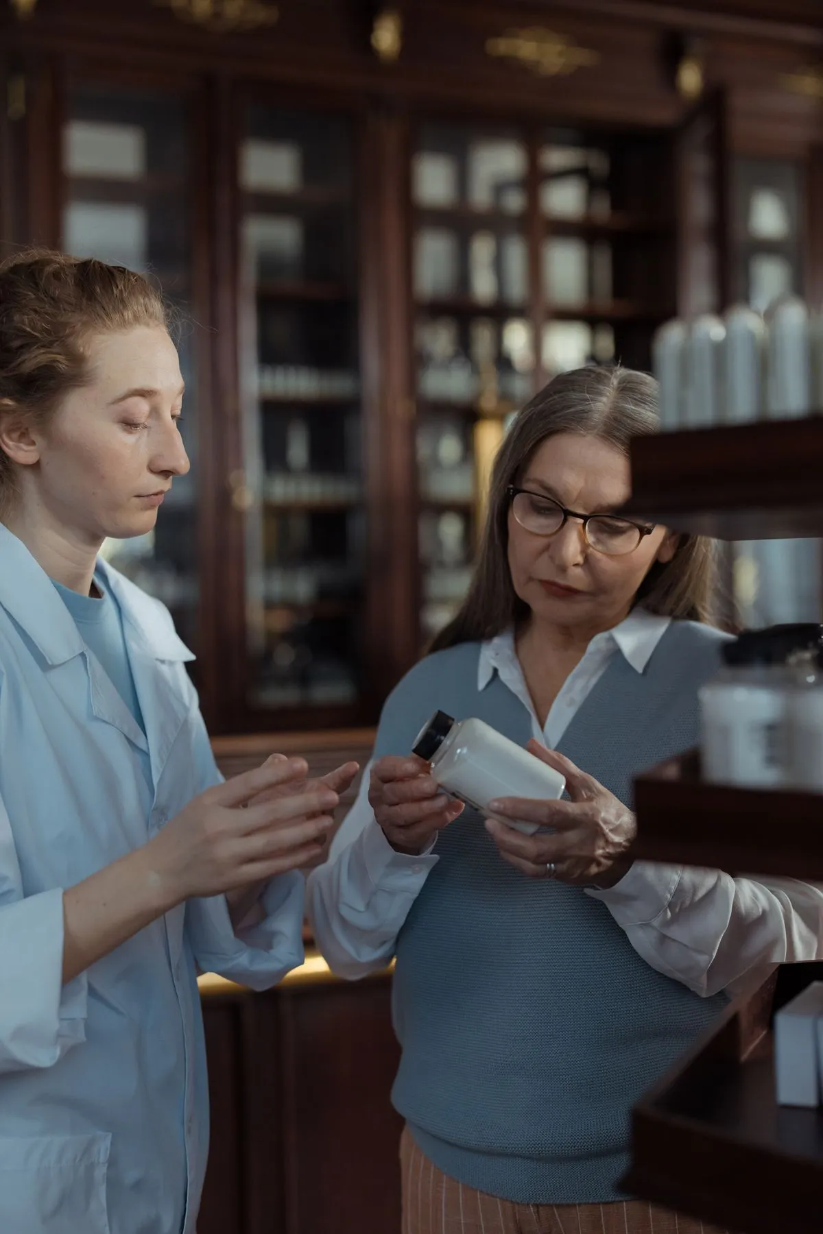 Farmacéutica explicando un medicamento a una clienta