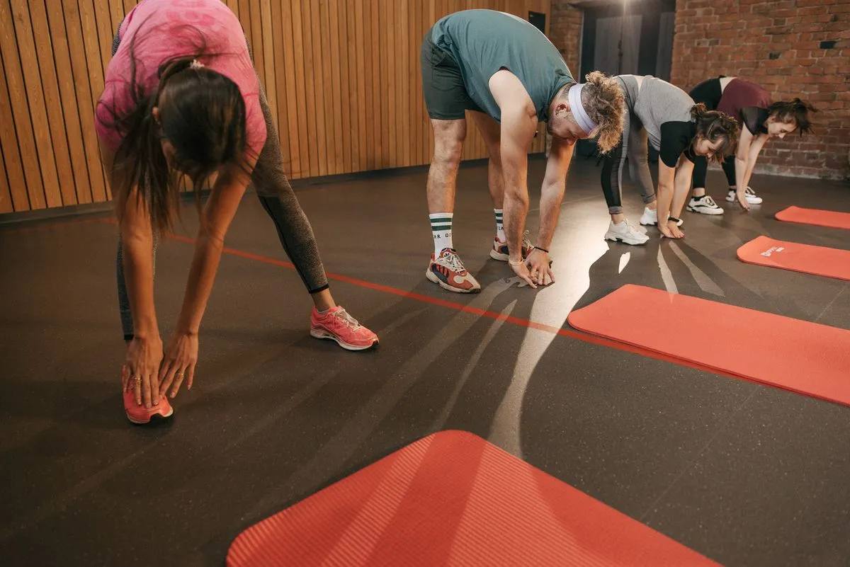 Grupo de adultos estirando las piernas sobre colchonetas