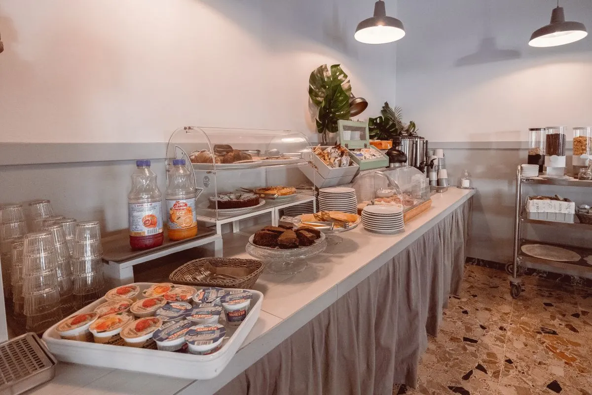 Mesa de desayuno con panificados, frutas, jugos y cereales