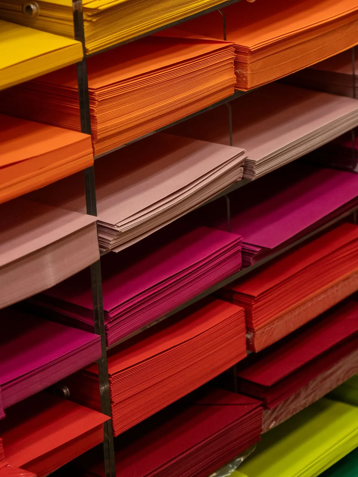 Pilas de papeles y cartulinas de colores en un estante