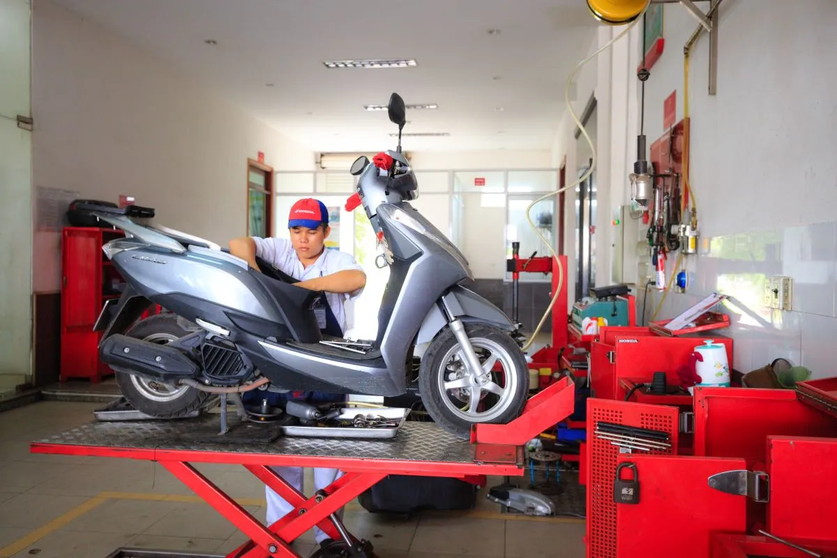 Mecánico haciendo el service de una scooter sobre el elevador