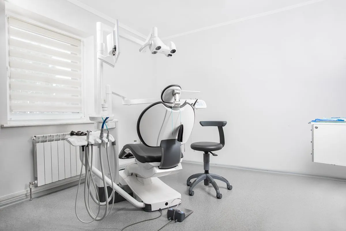 Consultorio odontológico blanco y luminoso con el sillón listo