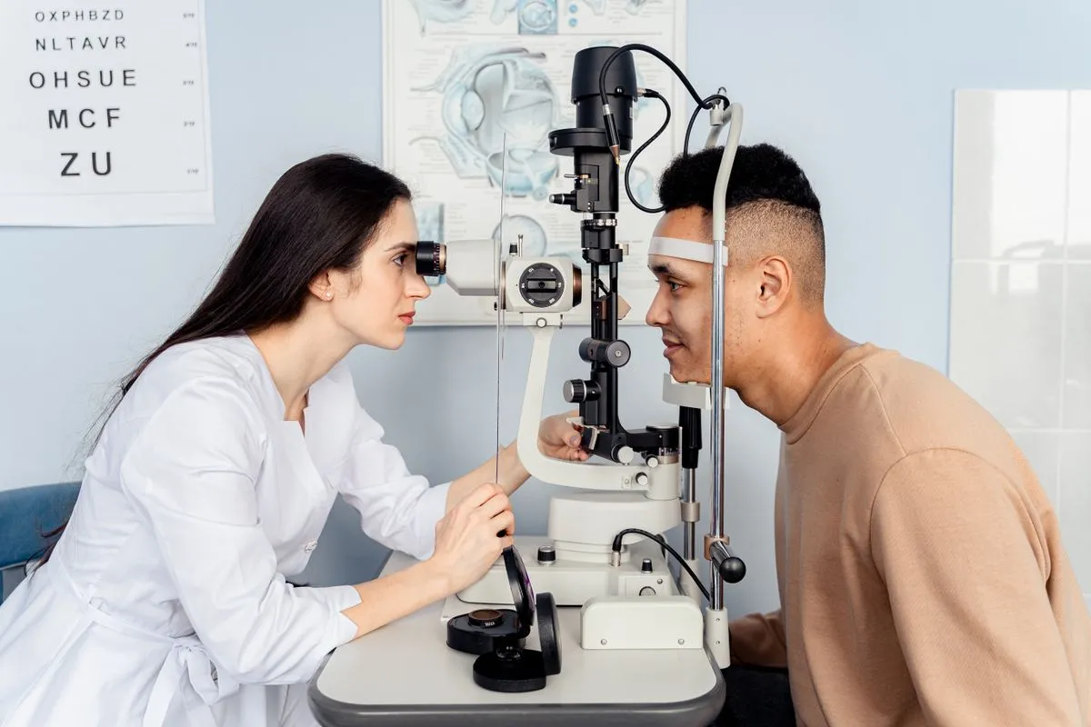 Profesional revisando la vista de un paciente con un equipo de lámpara