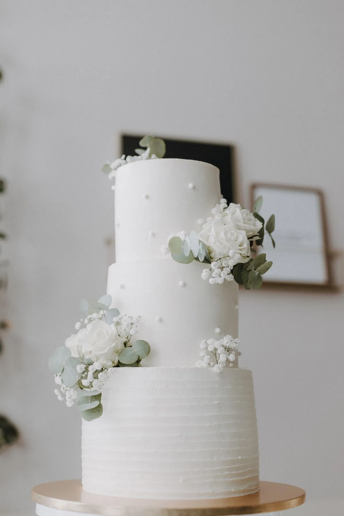 Torta de bodas blanca de tres pisos con flores