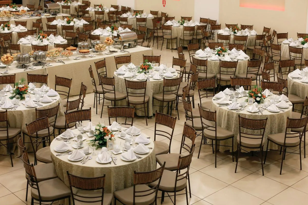 Salón con mesas redondas vestidas y centros de mesa