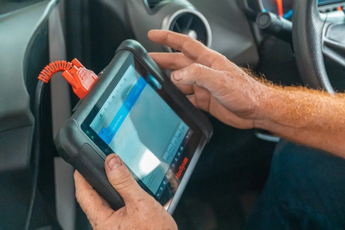 Mecánico usando un escáner de diagnóstico dentro del auto