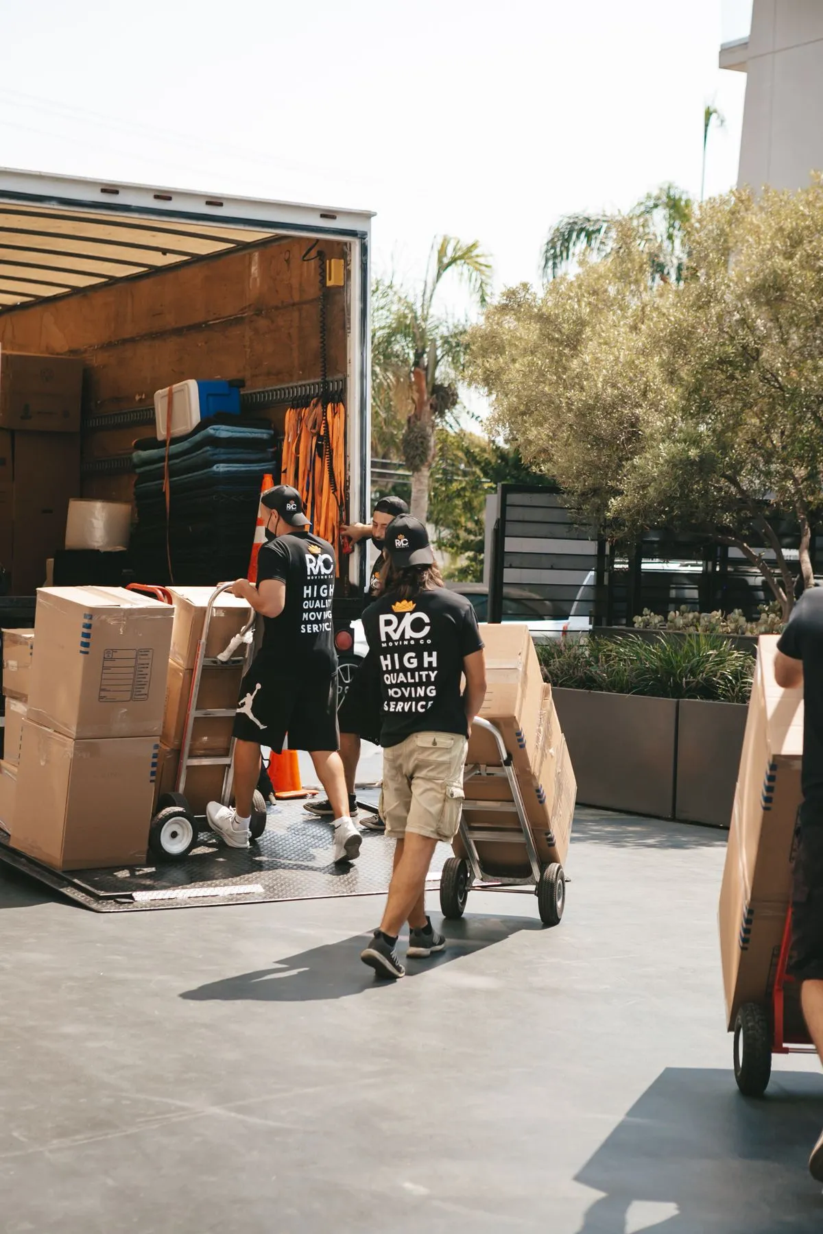 Equipo de ayudantes descargando cajas de un camión con carretillas