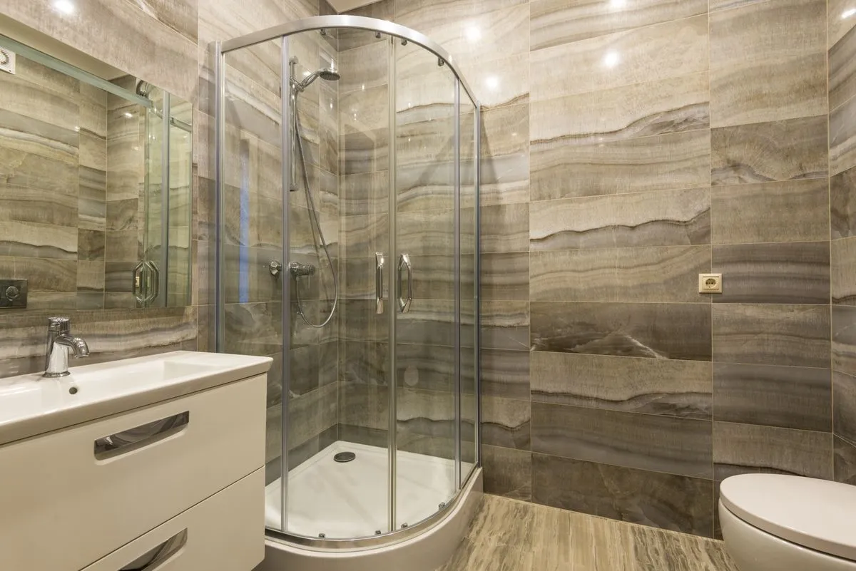 Baño moderno con mampara de vidrio curva